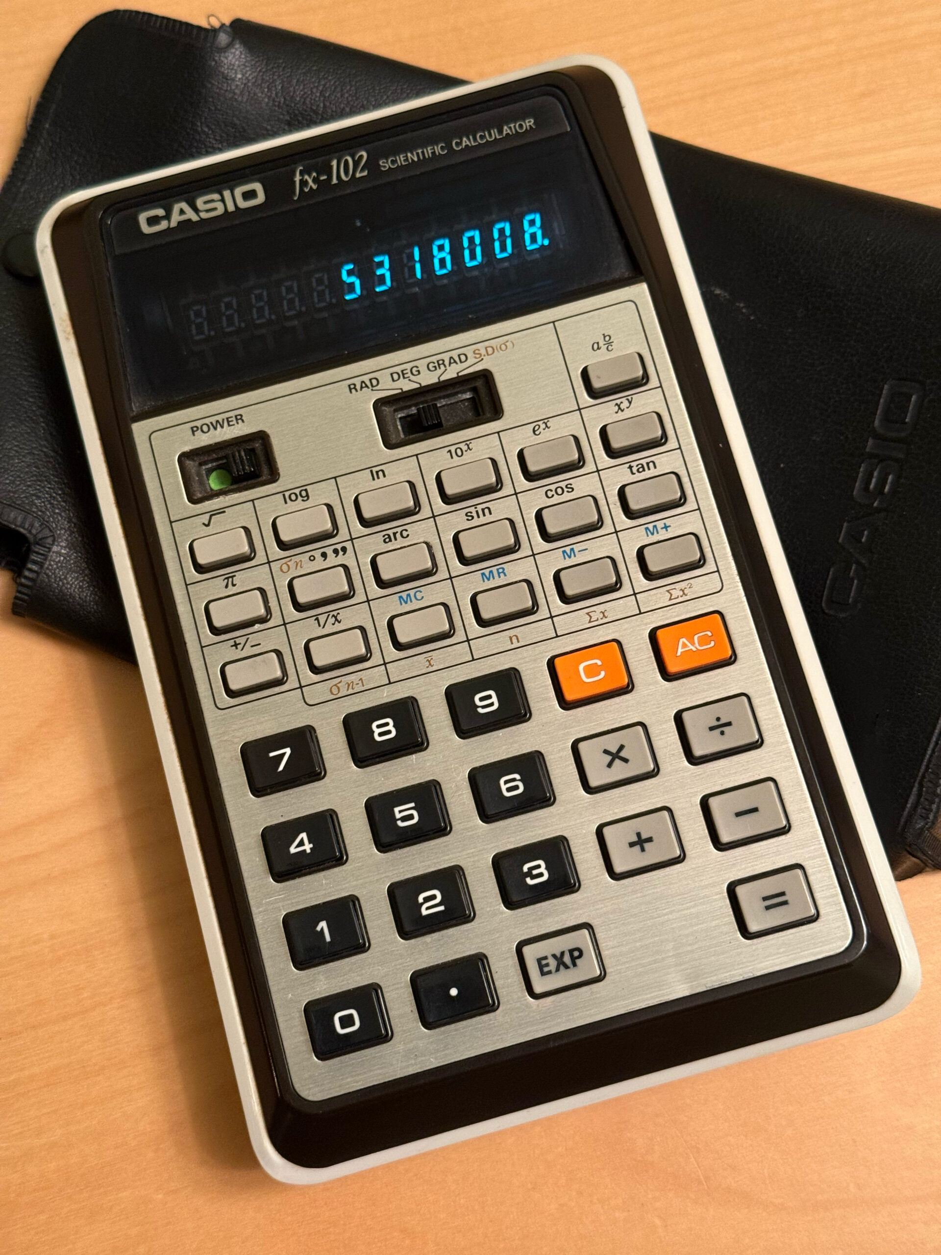 A Casio fx-102 calculator resting on its slip case. The display reads 5318008 - something familiar to anyone who's ever turned a calculator upside-down.