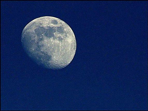 A grainy low-resolution scan of a 35mm film photo of the moon, taken many years ago using a series of lenses and teleconverters.